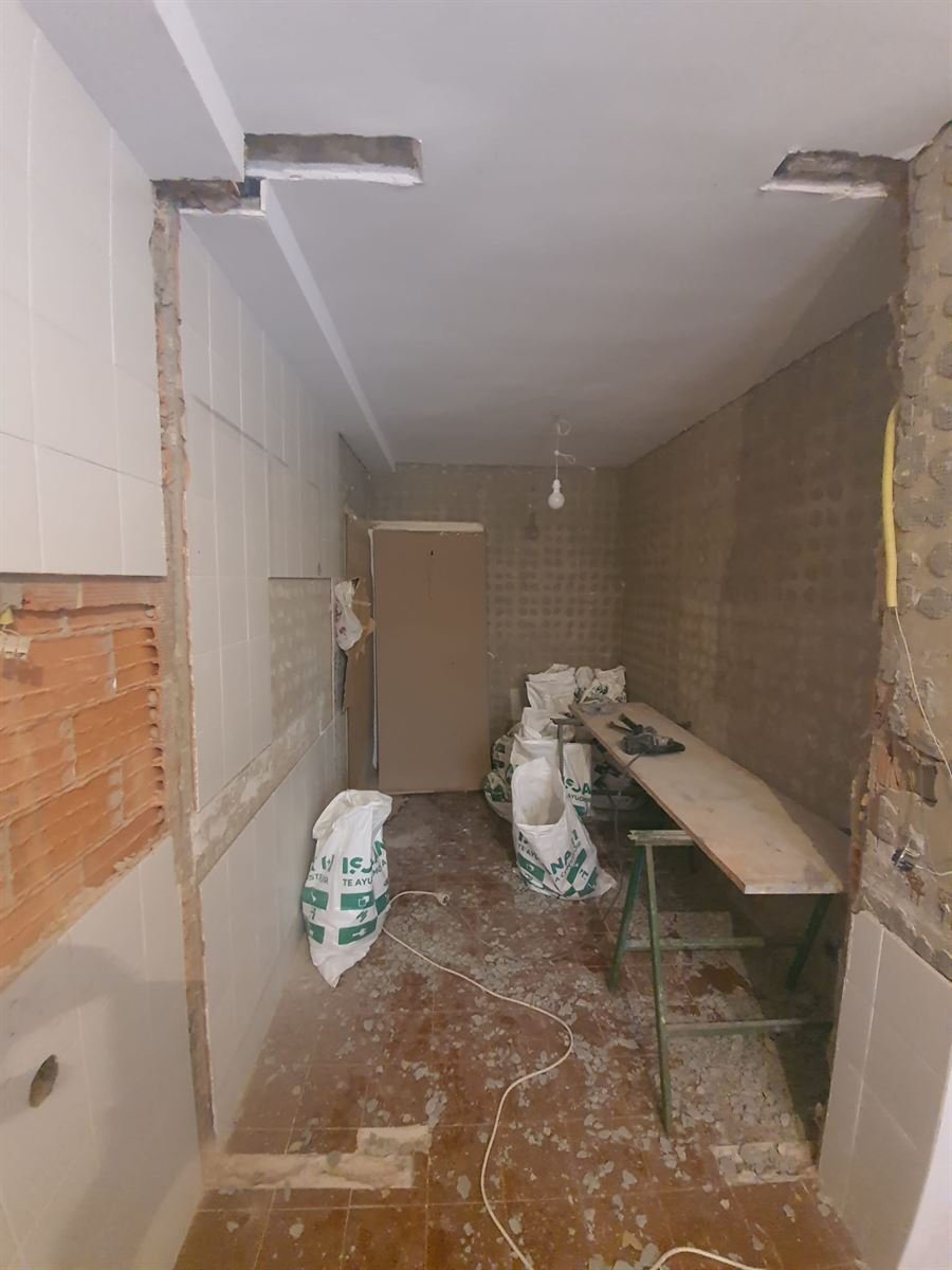 La cocina con el alicatado y el pavimento ya levantados, y los dinteles de las aberturas a la vista