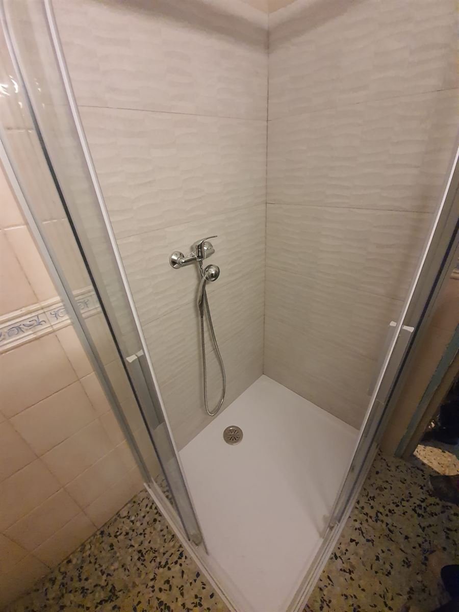 Plato de ducha colocado con la grifería nueva y el alicatado rehecho en la zona de ducha