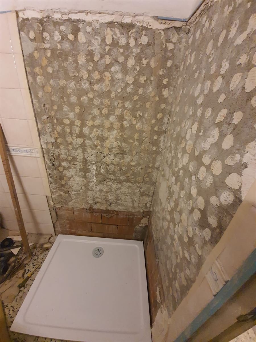 El hueco de la bañera picado hasta la pared y el plato de ducha nuevo antes de colocarlo