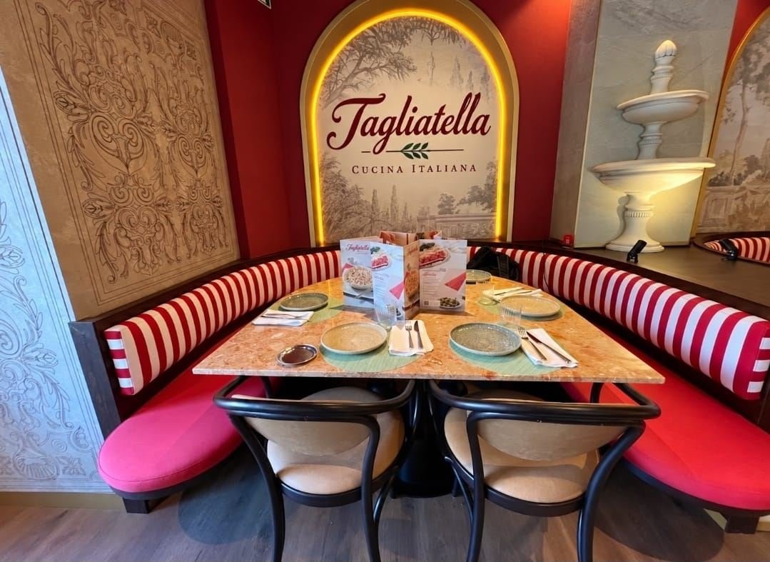 Comedor del restaurante terminado, con el rótulo iluminado y los bancos tapizados, y el falso techo ya cerrado
