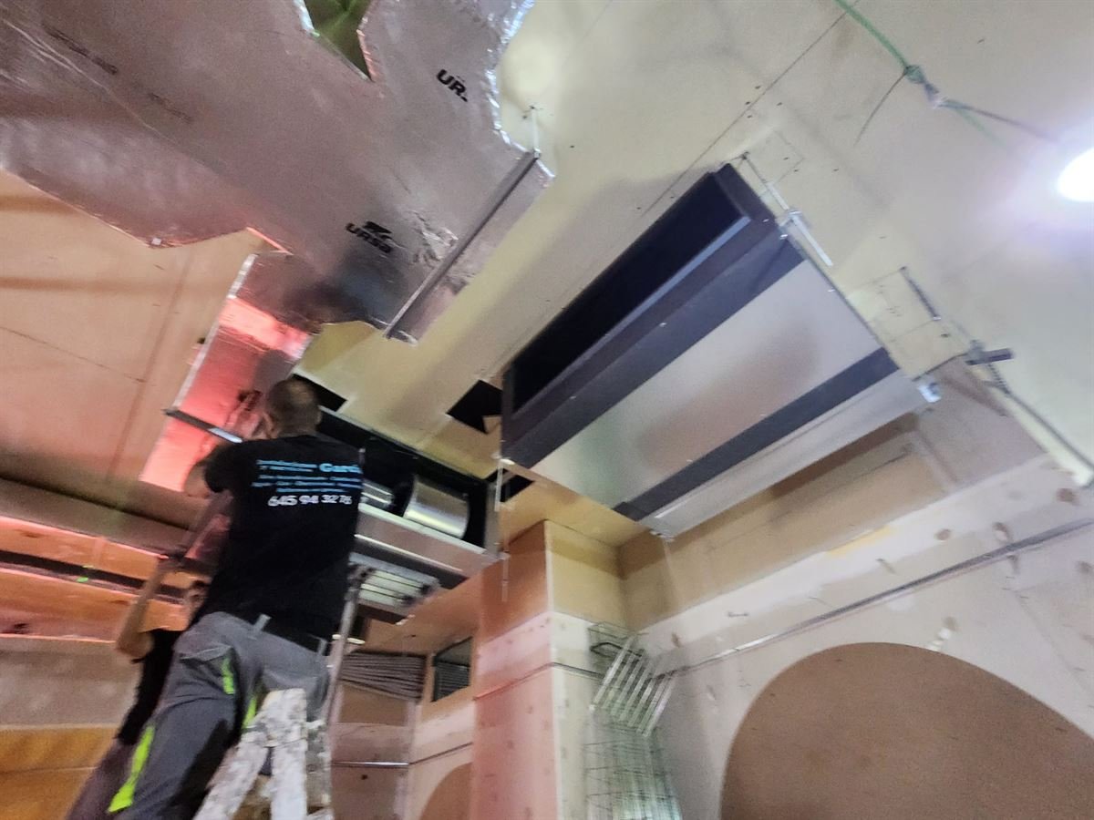 Técnico de Instalaciones y Servicios JGDR montando los conductos en el techo del restaurante