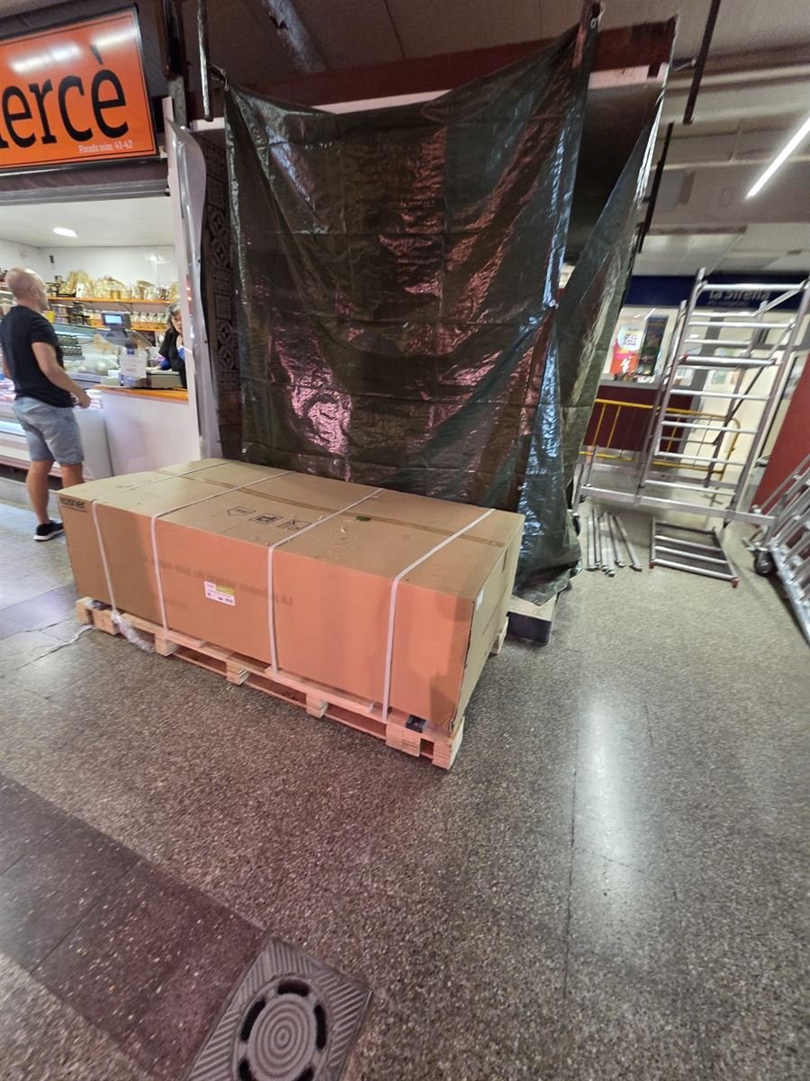 Material embalado sobre un palé dentro del mercado, con la zona protegida con lonas