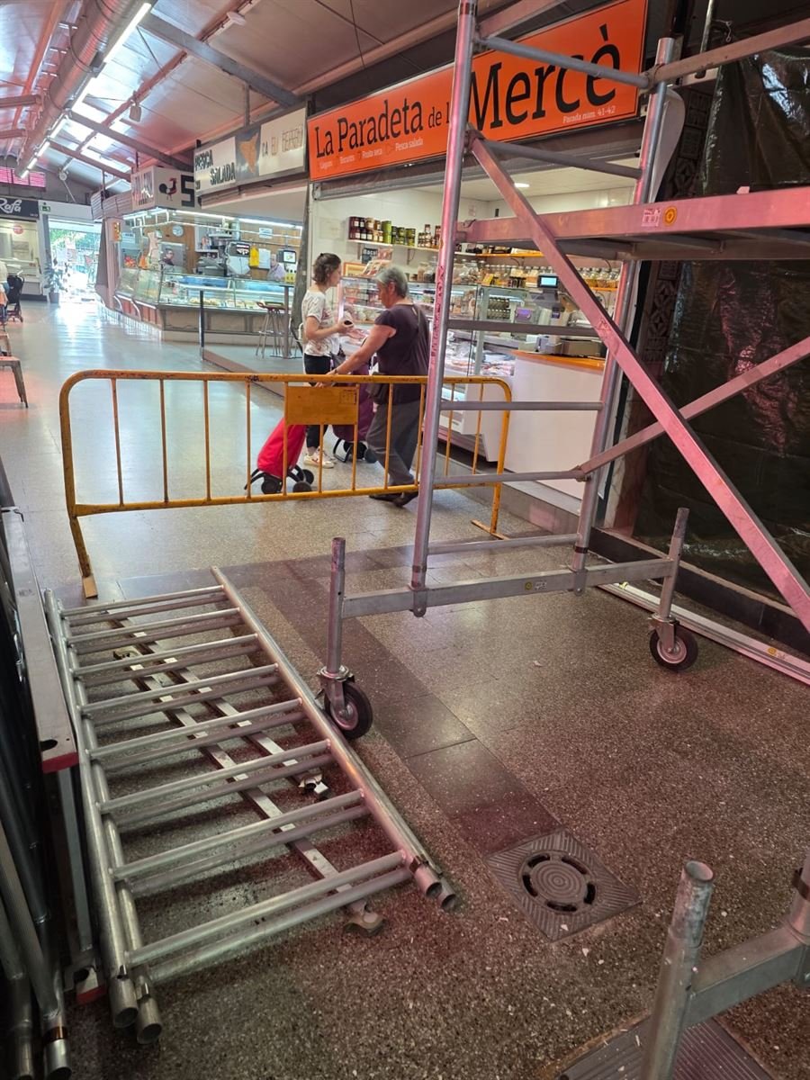 La zona de trabajo vallada dentro del mercado mientras las paradas siguen atendiendo