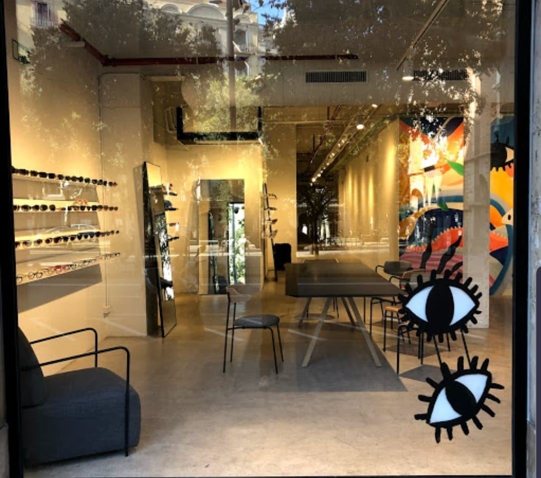 Interior de la óptica terminada, con los expositores de gafas y la iluminación ya en marcha