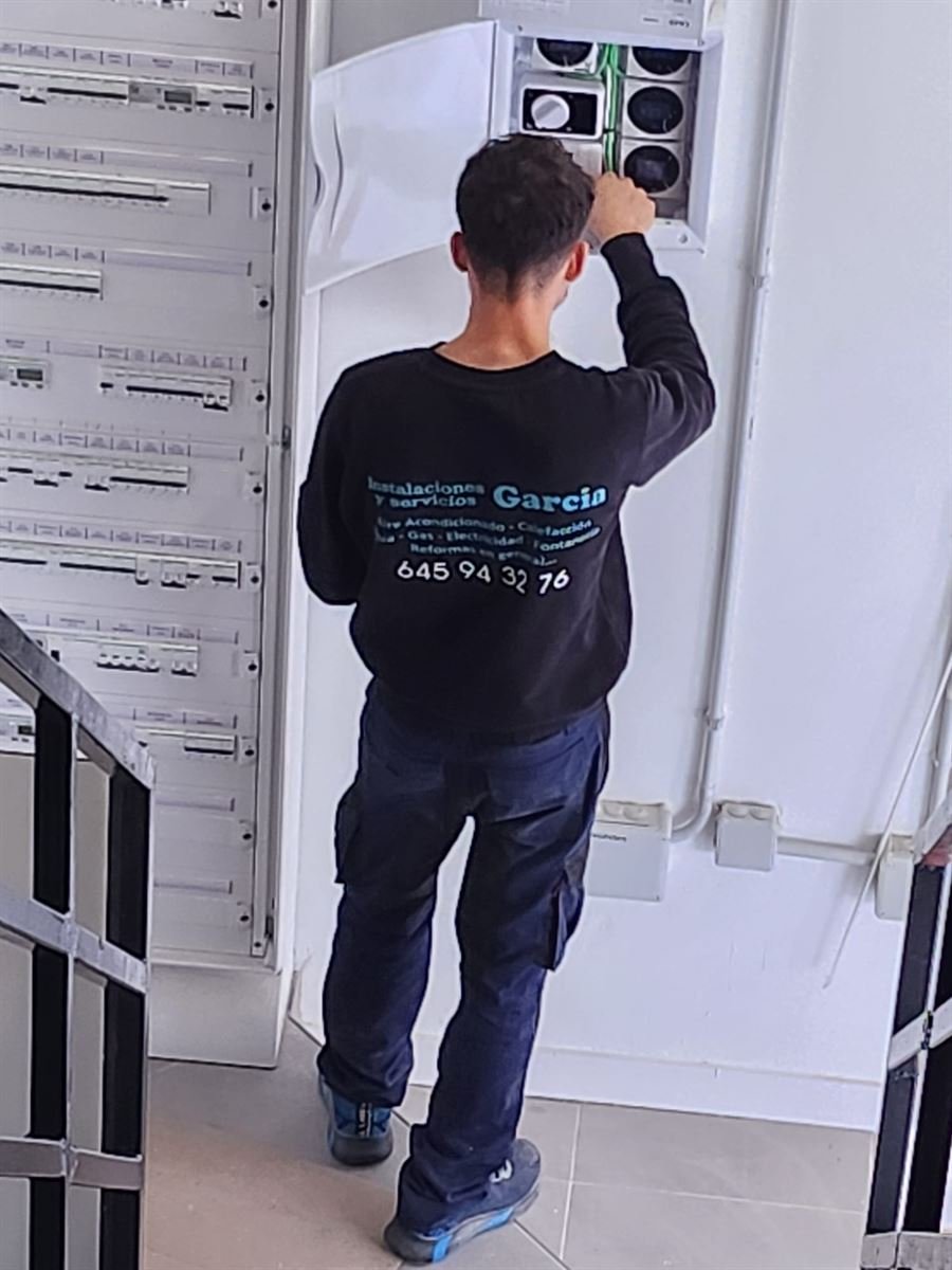 Técnico de Instalaciones y Servicios JGDR trabajando en el cuadro eléctrico de la tienda