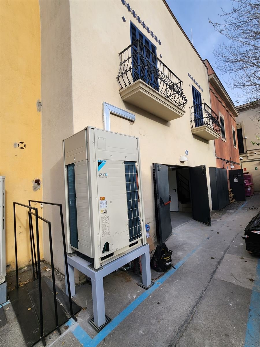 Unidad exterior Daikin VRV 5 instalada sobre bancada en el patio de servicio de la tienda