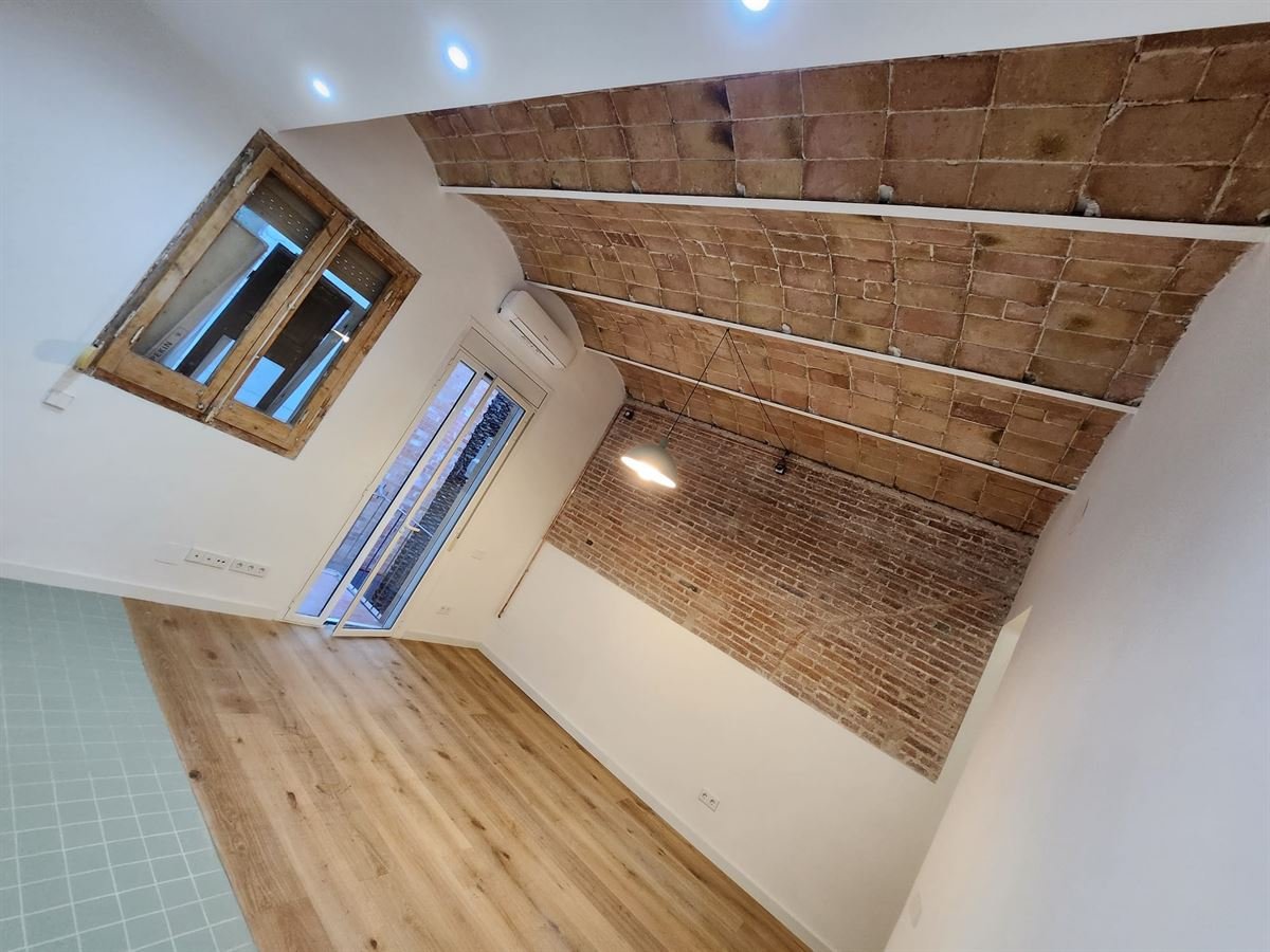 Salón acabado con la bóveda restaurada, la unidad interior de aire acondicionado y las ventanas de madera