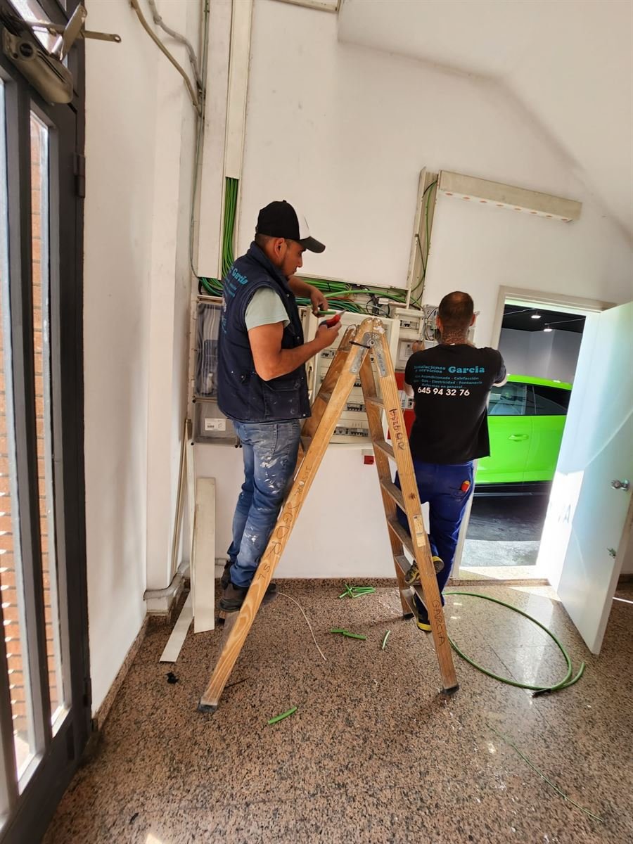 Técnicos de Instalaciones y Servicios JGDR pasando las líneas frigoríficas por el interior del local